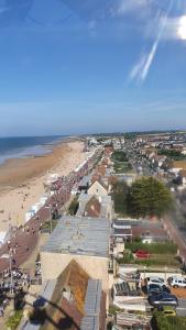 - une vue sur une plage avec une foule de personnes dans l'établissement JUNO Appart, à Courseulles-sur-Mer