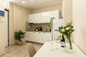 a kitchen with a table with flowers and wine glasses at Appartamento Al Castello Avezzano in Avezzano