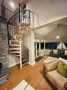 sala de estar con escalera de caracol y sofá en Conree Lodge en Castlemaine