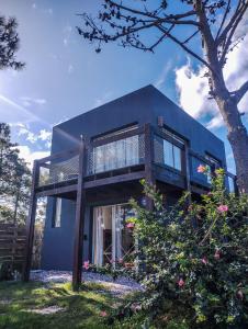 une maison avec un balcon sur le côté de celle-ci dans l'établissement Iona, à Punta del Diablo