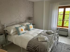 a bedroom with a white bed with blue and white pillows at La Maison Mignonne in Azerables