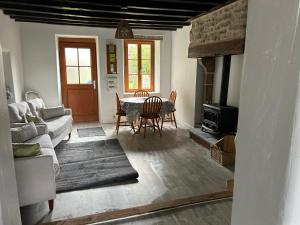 ein Wohnzimmer mit einem Tisch und einem Kamin in der Unterkunft La Maison Mignonne in Azerables