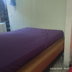 Cama en habitación con sábanas púrpuras en Hostel parque ecológico, en Juazeiro do Norte