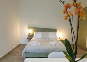 um quarto com uma cama e um vaso com flores em Fresia B&B em Tuscania