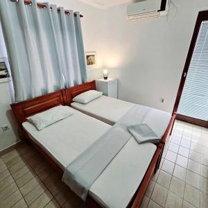 1 dormitorio con 2 camas y ventana en Hotel Bravo plus, en Budva