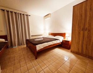 1 dormitorio con 1 cama con marco de madera en Hotel Bravo plus, en Budva