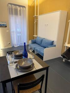 - un salon avec une table, des verres à vin et un canapé dans l'établissement Vicolo Muratori 1, à Moncalieri