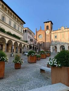 una via cittadina con piante in vaso e una chiesa di Vicolo Muratori 1 a Moncalieri