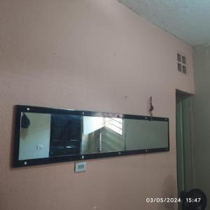 espejo grande en la pared de una habitación en Hostel parque ecológico, en Juazeiro do Norte