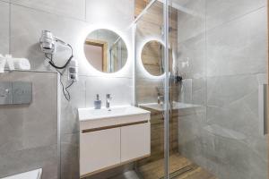 a bathroom with a white sink and a shower at Bieszczadzkie Siedlisko in Polańczyk