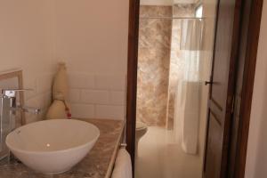 a bathroom with a white sink and a shower at Habitaciones con amplia terraza in Encarnación