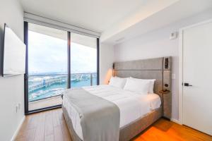 ein Schlafzimmer mit einem großen Bett und großen Fenstern in der Unterkunft Apartment Offering Direct Bay Views in Miami