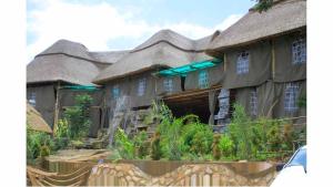 a large house with a thatched roof at Loginecoresort in Lukunyu