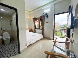 a bedroom with a bed and a bathroom with a window at Nhà Nghỉ Ngọc Long in Mộc Châu