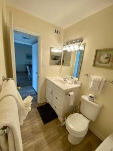 a bathroom with a toilet and a sink and a mirror at Lighthouse Point Rental 8B in Tybee Island