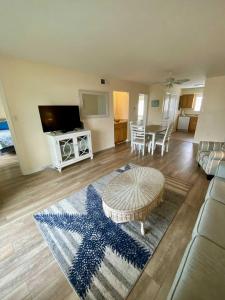 a living room with a star rug and a table at Lighthouse Point Rental 8B in Tybee Island