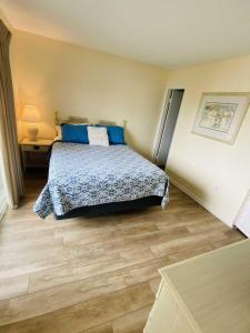 a bedroom with a bed with blue pillows at Lighthouse Point Rental 8B in Tybee Island