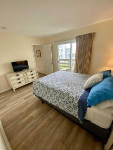 a bedroom with a bed and a television in it at Lighthouse Point Rental 8B in Tybee Island