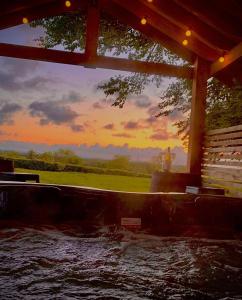 a view of a water fountain with a sunset in the background at Thornfield Farm Luxury Glamping Pods, The Dark Hedges, Ballycastle in Stranocum