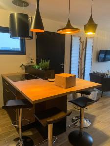 cocina con mesa de madera y taburetes en una habitación en LE REFUGE DE LA BAIE, en Beaussais sur Mer