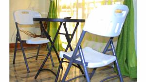 two white chairs and a black table and chairs at Loginecoresort in Lukunyu