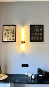uma cozinha com um balcão com duas fotografias na parede em Appartamento moderno Freidour, metro Rivoli em Turim