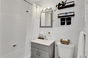 a bathroom with a sink and a toilet and a mirror at Victoria Park Regency in Fort Lauderdale