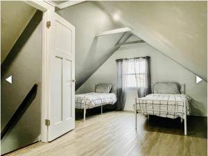 a attic room with two beds and a window at Patel in Beach Haven