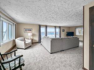 ein Wohnzimmer mit einem Sofa, einem TV und Fenstern in der Unterkunft 5 Bryant Road Bourne Sunset Cottage in Buzzards Bay