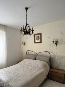a bedroom with a bed and a chandelier at Le allodole in Bellano