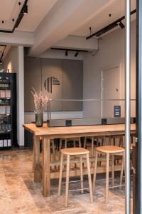 a large wooden table in a room with stools at The Pier Ateliers by Daniel&Jacob's in Copenhagen