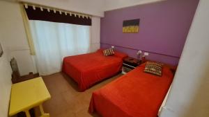 2 camas en una habitación con paredes moradas y moradas en Hotel del Paseo en Mar del Plata