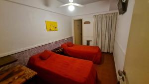 un soggiorno con 2 divani rossi e un ventilatore a soffitto di Hotel del Paseo a Mar del Plata