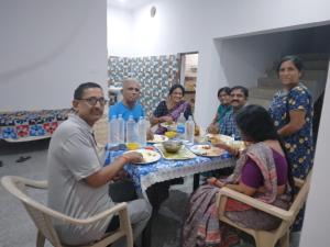 Un groupe de personnes assises autour d'une table à manger dans l'établissement Happy Homestay, à Khajurâho