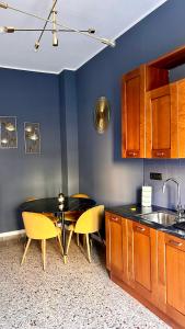 uma cozinha com uma mesa e algumas cadeiras amarelas em Appartamento moderno Freidour, metro Rivoli em Turim
