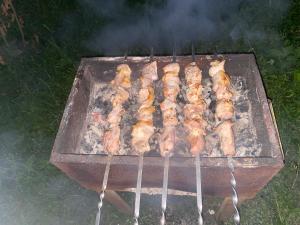 a bunch of skewered meat cooking on a grill at Old House in Lagodekhi