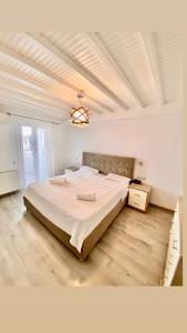 ein Schlafzimmer mit einem großen Bett in einem weißen Zimmer in der Unterkunft Beautiful apartment in Mykonos town ! in Mykonos Stadt