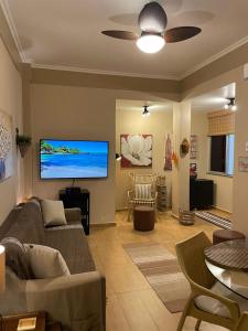 uma sala de estar com um sofá e uma televisão de ecrã plano em BeM Ipanema no Rio de Janeiro