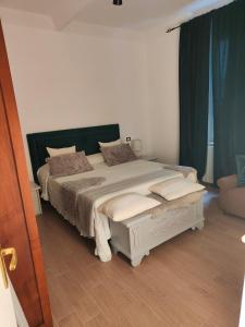 ピオンビーノにあるApartment Salivoliのベッドルーム1室(緑のカーテン付きの大型ベッド1台付)