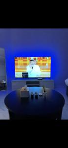 Camera blu con tavolo di fronte alla TV di Cozy studio at Al aqiq a Riyad