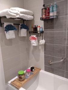 a bathroom with a shower and a bath tub with a shelf at House Rose 1 in Prescot