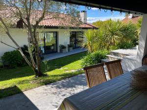 a house with a table and chairs in the yard at Maison contemporaine Socoa in Urrugne