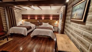 2 camas en una habitación con suelo de madera en Hotel de Sal Atipax en Uyuni
