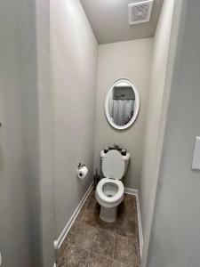 uma pequena casa de banho com WC e espelho em Spacious 4 BR in Suburban Metro Atlanta em McDonough