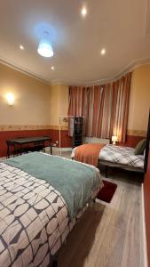 Habitación de hotel con 2 camas y mesa en 25 Minutes to Central London Rooms 35, en Londres