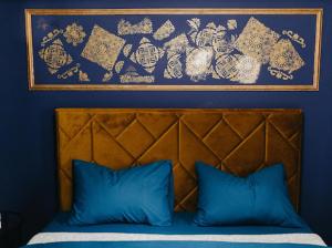 a blue wall with a picture above a bed with blue pillows at NL Studio Apartments in Nevesinje