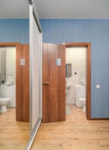 a bathroom with two doors and two sinks and toilets at Блакитна студия, Південний вокзал 5 хвилин in Kharkiv