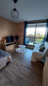 a bedroom with two beds and a tv and a window at Studio Le Cosy in Montrichard