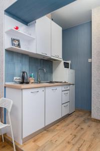 a kitchen with white cabinets and a sink at Блакитна студия, Південний вокзал 5 хвилин in Kharkiv
