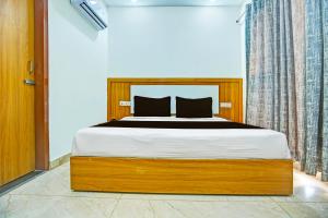 a bedroom with a bed with a wooden frame at OYO Hotel U.K GREEN VALLEY in Chandīgarh